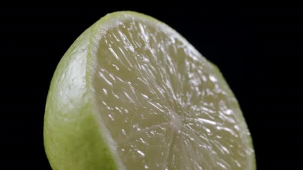Vídeo de limão fiação verde fatiado no fundo preto — Vídeo de Stock