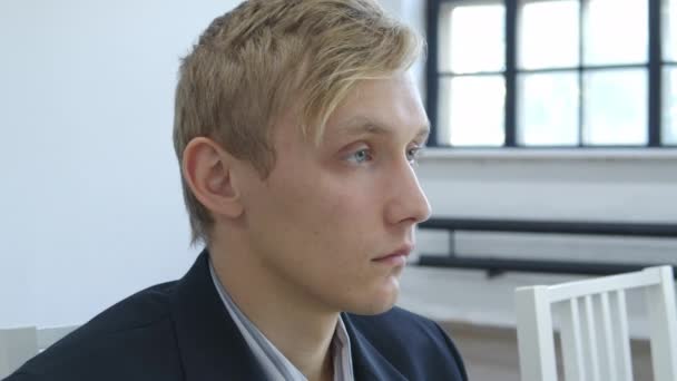 Видео молодого безмятежного блондина в куртке — стоковое видео