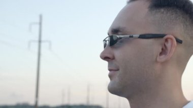 Güneş gözlüklü bir adamın keyifli yürüyüşünün videosu.