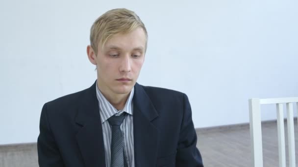 Video van brutale blonde man zit in het wachten — Stockvideo