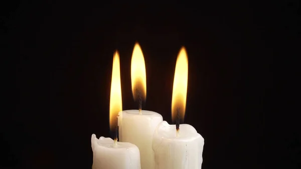 Foto de la quema de tres velas sobre fondo negro —  Fotos de Stock