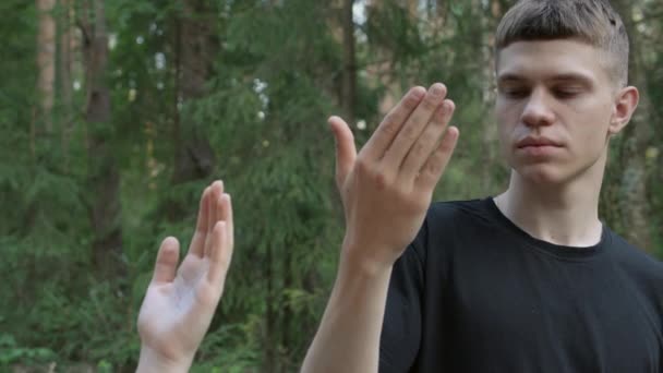 Video eines jungen Mannes, der auf seine Handfläche blickt — Stockvideo