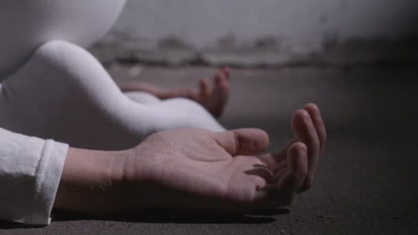 Close-up video af gal mand i hvidt tøj liggende i fosterstilling – Stock-video