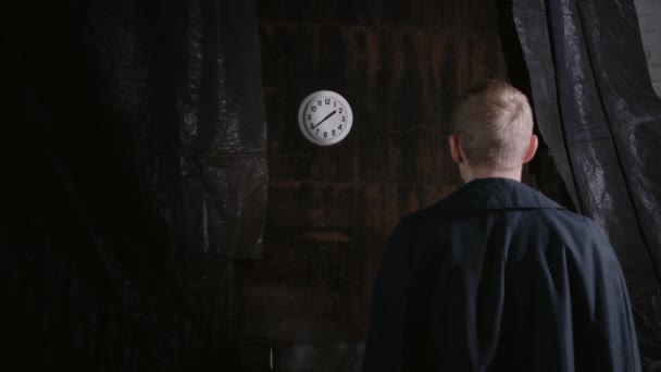 ブロンド男の撮影背を向けてと見て回転時計の顔 — ストック動画