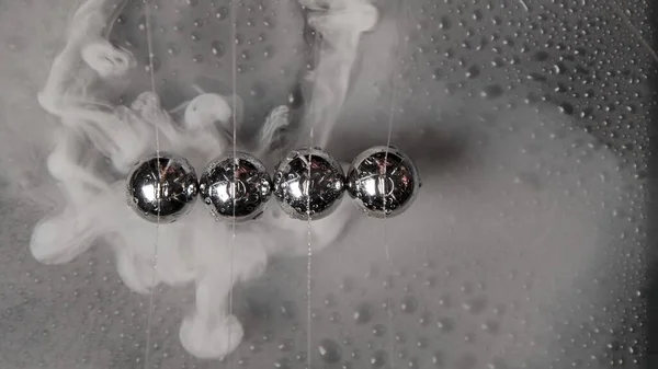 Image of wet steel newton balls with smoke, top view — Stockfoto