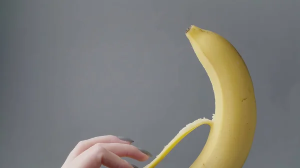 Vídeo de mão feminina descascando banana amarela — Fotografia de Stock