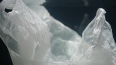 Su altında yüzen beyaz paketin yakın çekim videosu