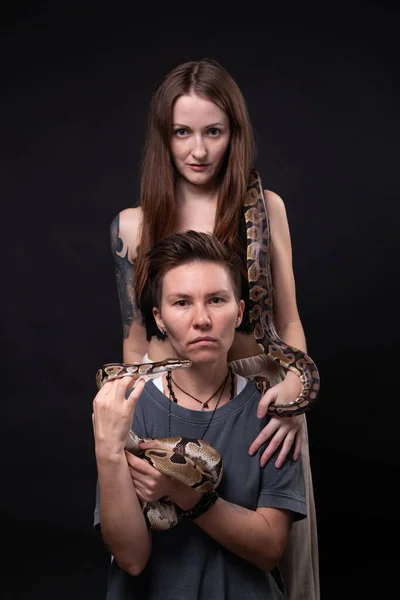 Photo of two women with snakes on black background — Stock Photo, Image