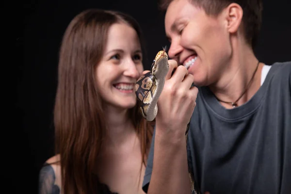 Photo of two women with python on black background — Stock Photo, Image