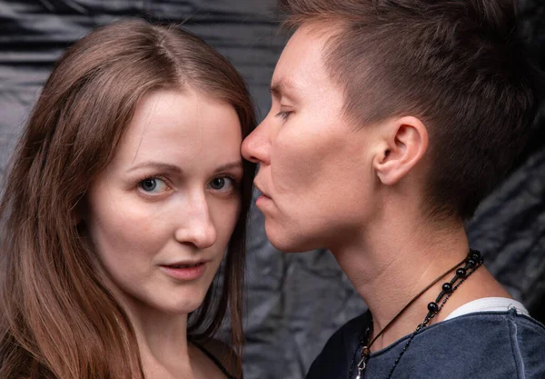 Foto van twee zoenende homoseksuele vrouwen op donkere achtergrond — Stockfoto