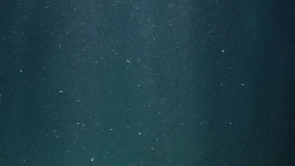 青の背景にグレアで水中のほこりの撮影 — ストック動画