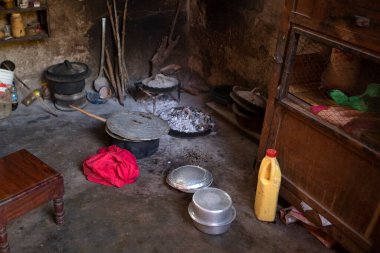 Kulübenin içindeki mutfak. Afrika mutfağının içi ocak ve ocakla dolu. Mütevazı eski tarz mutfak, tencere ve çatal bıçaklar yerde yatıyordu. Afrika köyündeki kulübe mutfağı..