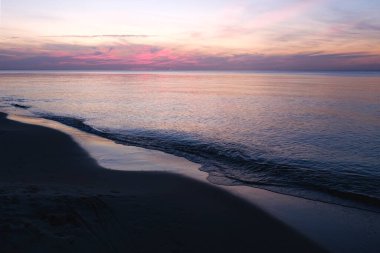 Baltic sea sunset sky, silver purple colors of sea calm water. Romantic beach landscape.