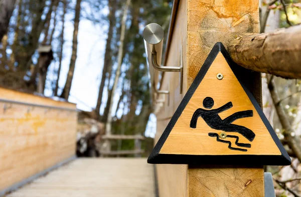 Slippery when wet - Wooden Sign in the Park — Stock Photo, Image