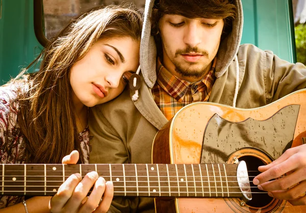 Romântico jovem casal tocando guitarra ao ar livre após a chuva — Fotografia de Stock