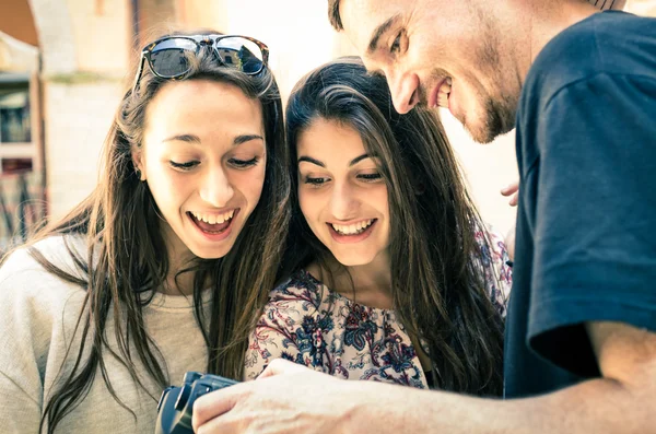 Knappe jongen toont foto's aan mooie meisjes — Stockfoto