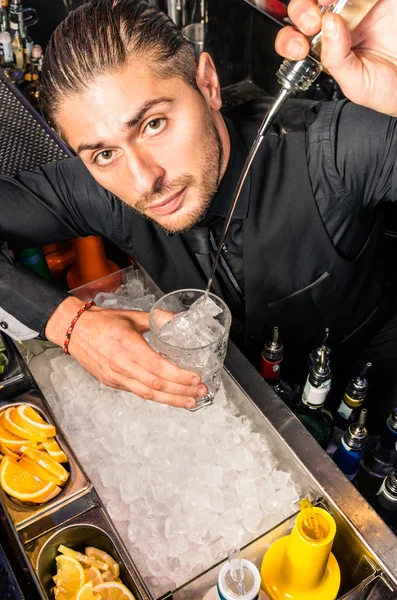 Amerikaanse barman gieten een geest in het glas met een gladde vrije stijl verplaatsen — Stockfoto