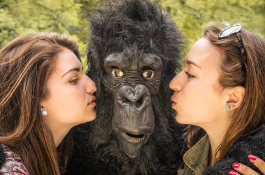 Two Girls kissing an astonished Gorilla clipart