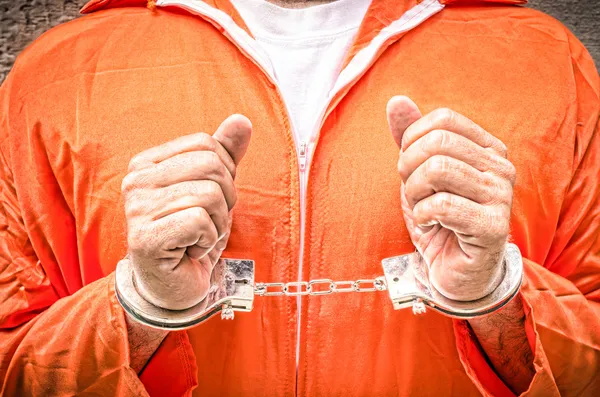 Připoutané ruce - oblečení oranžové věznice Guantánamo — Stock fotografie