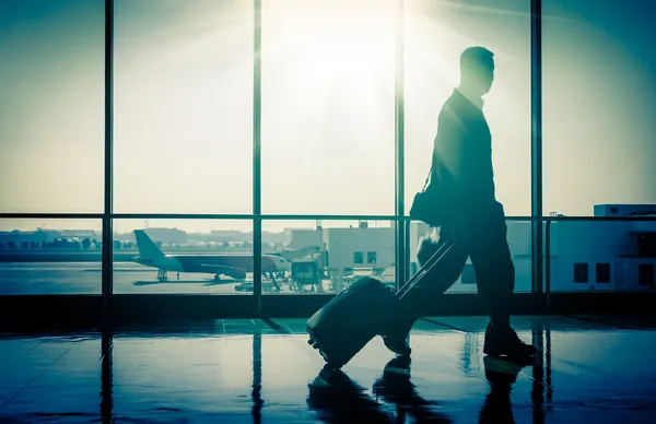 Człowiek na lotnisku z walizką — Zdjęcie stockowe