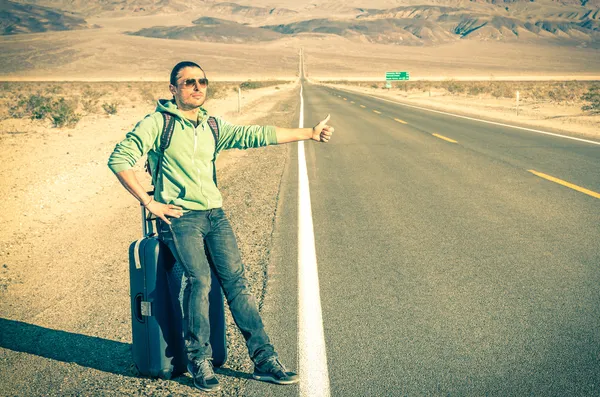 Young handsome man hitch-hiking in the Death Valley - California — Stock Photo, Image