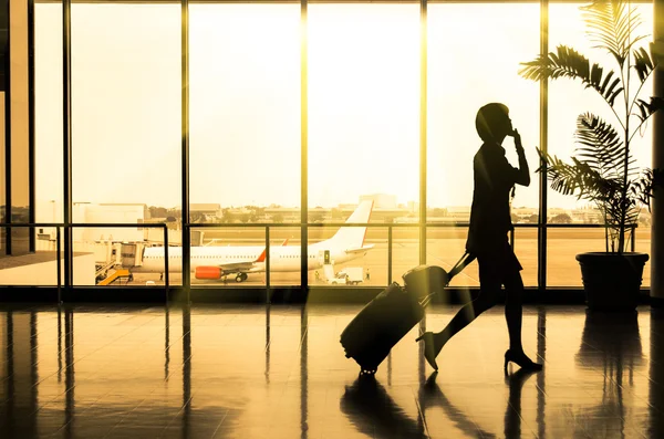 Affärskvinna på airport - silhuetten av en passagerare — Stockfoto