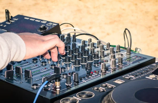 Mano de un DJ tocando música en un controlador de mezcla profesional — Foto de Stock