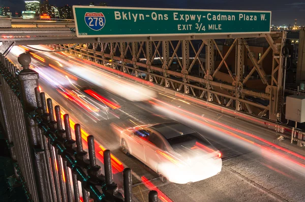 NEW YORK - NOVEMBER 22, 2013: cars speeding on the Brooklyn Bridge from Manhattan to Brooklyn. The national historic landmark was completed in 1883 and has a main span of 1,595.5 feet (486.3 m) — Stock Photo, Image