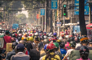 HO CHI MINH CITY, VIETNAM - FEBRUARY 2, 2013: traffic jam with a congestion of scooters and people with colorful helmets. There are approximately 340,000 cars and 3,5 million motorcycles in the city. clipart