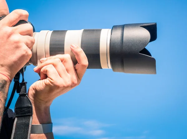 Photographer outdoors with big zoom digital lens as professional equipment getting ready to shoot a photo — Stock Photo, Image