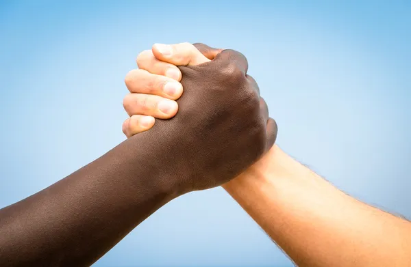 Black and white human hands in a modern handshake to show each other friendship and respect - Arm wrestling against racism — Stock Photo, Image