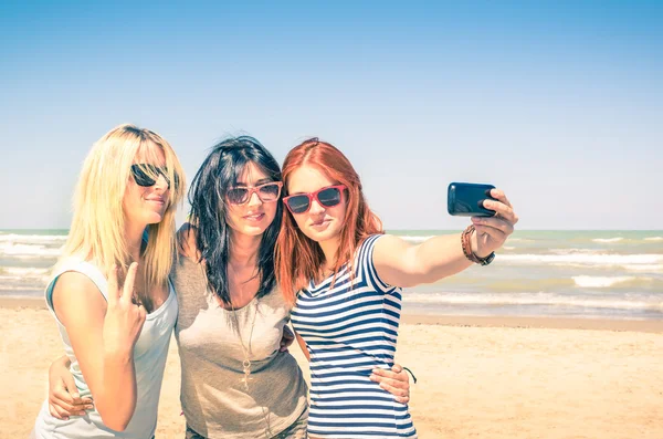 Grupo de amigas tomando un selfie en la playa - Concepto de amistad y diversión en el verano con nuevas tendencias y tecnología - Mejores amigos disfrutando del momento con un smartphone moderno —  Fotos de Stock