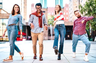 Şehir merkezinde yürüyen çok kültürlü arkadaşlar çılgınca hareketler yapıyorlar mutlu çocuklar ve kızlar şehir sokaklarında parti havasında eğleniyorlar üniversite öğrencileri seyahat tatillerinde parlak, canlı filtreler.