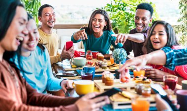 Arkadaş grubu kahve barının çatısında konuşuyor. Brunch saatinde kafeteryanın dışında çeşitli insanlar birlikte eğleniyor. Kafe mekanında mutlu erkekler ve kızlarla yaşam tarzı konsepti.