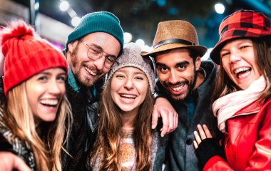 Erkekler ve kızlar gece sıcak moda kıyafetleriyle selfie çeken en iyi arkadaşlar milenyel insanların kış tatilinde açık havada eğlendikleri mutlu bir yaşam tarzı konsepti.