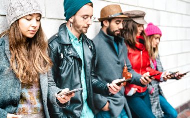 Akıllı telefon kullanan milenyuma mensup erkekler ve kızlar - akıllı telefon bağımlısı insanlar - her zaman bağlı gençlerle yaşam tarzı konsepti - ilk sol cep telefonuna odaklı canlı filtre