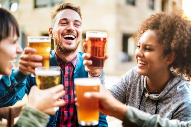 Bira fabrikası restoranında bira içen ve bira içen çok kültürlü mutlu arkadaşlar - erkek ve kadınların dışarıda eğlendiği meşrubat tarzı konsept - erkek ve erkek odaklı parlak sıcak filtre