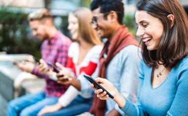 Şehir merkezinde akıllı telefon kullanan çok kültürlü bir grup - cep telefonu bağımlısı Milenyal arkadaşlar - Doğru kadına odaklı milenyumlarla bağlantılı teknoloji kavramı