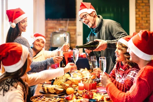 Millenial Freunde Auf Weihnachtsmützen Feiern Weihnachten Mit Champagner Und Süßigkeiten — Stockfoto