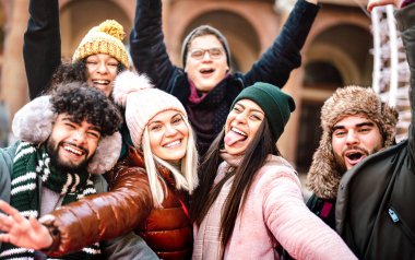 Çok kültürlü erkekler ve kızlar sıcak moda kıyafetleriyle selfie çekiyorlar - Milenyum insanlarının kış tatillerinde dışarıda eğlendikleri mutlu yaşam tarzı konsepti - Sıcak karşıtlık filtresi