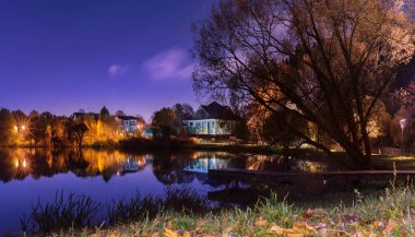 Moskova. 15 Ekim 2021. Gece Meshchersky Park 'ında altın sonbahar, ay ışığı ve sokak lambalarıyla aydınlanıyor..