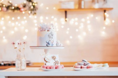 Bokeh arka planında kek. Kutlama yemeği. Çiçekli pasta, resim, makarna ve lolipop.