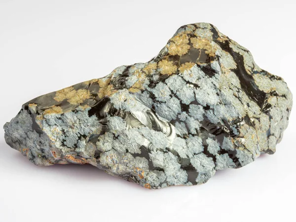 Obsidiana de neve mineral. A pedra é de origem vulcânica sobre um fundo branco. — Fotografia de Stock