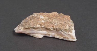 Koyu bir arka planda kalsit pembesi. Tedavi edilmemiş doğal taş.