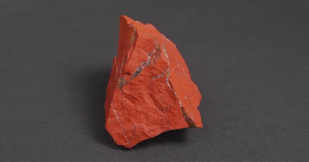 Jastic es rojo sobre un fondo oscuro. Piedra ornamental semipreciosa. — Vídeos de Stock