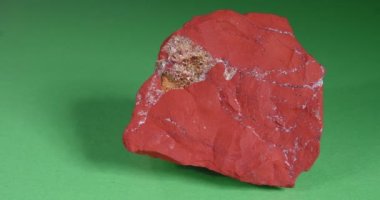 Jastic yeşil arka planda kırmızıdır. Yarı değerli süs taşı..