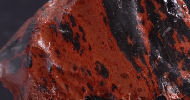 Обсидиановый красное дерево. Магнитный камень. Текстура крупным планом. — стоковое видео