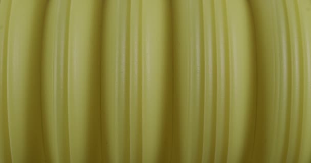 Tubería de corrugación de plástico macro. La textura del resorte comprimido es de cerca. Fondo amarillo. — Vídeos de Stock