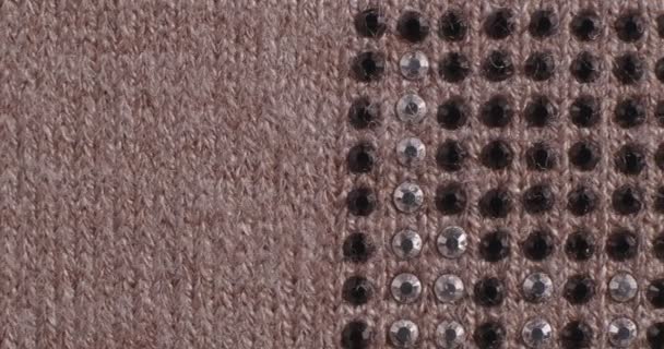 La texture de la partie tricotée est en gros plan. Le tissu est décoré avec des strass. — Video