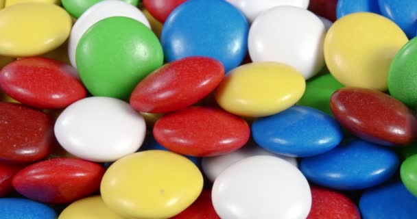 Sweets in the form of multi-colored pebbles, poured with colored glaze. — Stock Video